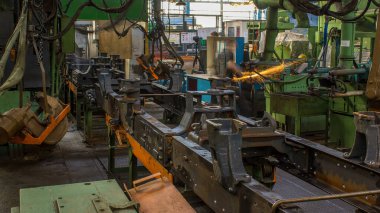 Konveyör montajı, traktörün gövdesini büyük endüstriyel fabrika zaman diliminde sahneleyecek. Çerçeve montajı kızgın perçinli metal bir masa üzerinde