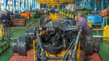 Konveyör montajı, traktörün gövdesini büyük endüstriyel fabrika zaman diliminde sahneleyecek. Çerçeve montajı, çamurluk kurulumu ve montajlanan diğer parçalar