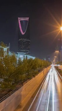 Riyad karayolu tüneli trafiğinin yer aldığı panoramik gece zaman çizelgesi, Krallık Kulesi Suudi Arabistan 'ın başkentinin en yüksek gökdeleni ve simgesi. Aydınlatılmış modern binalar çevre sahnesi