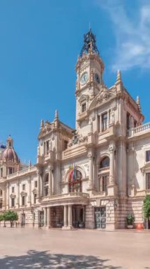 Valencia Belediye Binası Ajuntament de Valencia zaman atlaması Plaza de Ayuntamiento 'da. Mavi gökyüzünün altında saat kulesi olan tarihi bir bina. İspanya 'nın ana meydanında gezinen insanlar