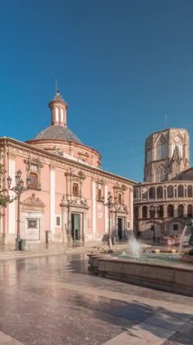 Valencias Plaza de la Virgen 'in zaman çizelgesini gösteren panorama, mavi gökyüzü altında Turia Fountain, Cathedral ve Virgen de la Virgen de los Desamparados' u sergiliyor.