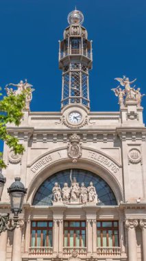 Valensiya 'daki tarihi posta ofisi Palau de les Comunicacions Belediye Meydanı Plaza del Ayuntamiento' da. Süslü cephe, yeşil ağaçlar ve İspanya şehir merkezinde mavi bir gökyüzü..