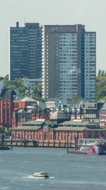 Hamburg 'daki Altona Balık Pazarı' nın zaman çizelgesi. Elbe Nehri 'ne yansıyan binaların olduğu tarihi bir pazar. Ticaret, kültür ve canlı liman manzarası. İskele vinçleri ve gökdelenler