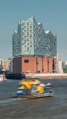 Hamburgs 'un ünlü Elbphilharmonie konser salonu, önünde gemiler ve tekneler. Arka planda Uberseebrucke ve Niederhafen, Hafencity rıhtımında. Almanya