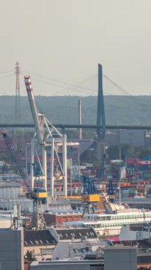 Hamburg kargo limanının hava zaman çizelgesi Elbe Nehri 'ndeki konteyner terminalleri, vinçler ve kargo gemileri. Rüzgar santrallerinde çalışıyorum. Tekneler ve gemiler geçiyor, deniz manzarası. Almanya