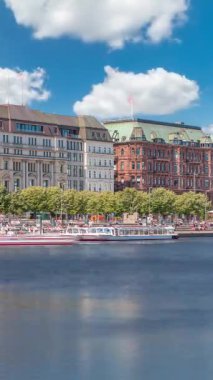 Almanya, Hamburg 'daki Binnenalster zaman ölçümüne bakın. Alster Gölü 'nün iç sularına yansıyan tarihi binalar mavi gökyüzünün altında. Gemili ve rıhtımlı manzaralı şehir manzarası