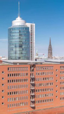 Modern Hamburg, Almanya 'nın hava zaman çizelgesi, konut ve ofis binalarının kırmızı tuğla cephelerini gösteriyor. Çok katlı evler ve kuleler bu canlı kentsel alanda çarpıcı bir şehir manzarası yaratıyor.