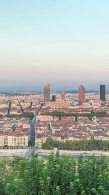 Gün batımında Fourviere Hill 'den Lyon' un panoramik hava görüntüsü. Ufuk çizgisinde Pont Marechal Juin, Rhone Nehri ve sıcak akşam ışığında aydınlanan ikonik şehir simgeleri yer alıyor.