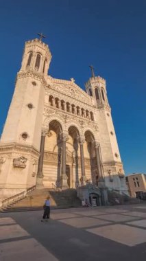 Fransa 'nın Lyon kentinde günbatımında Notre Dame de Fourviere Bazilikası' nın hiperlapse ön görüntüsü. Bu ikonik küçük bazilika sıcak ışıkla aydınlatılıyor. Tepenin tepesindeki zaman diliminden şehre bakıyor.