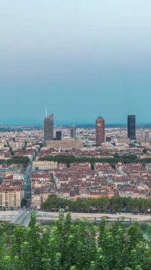 Gün batımından sonra Lyon 'un panoramik hava görüntüsü Fourviere Hill' den gece dönüşümüne kadar. Ufuk çizgisinde Rhone Nehri ve sıcak bir akşamda aydınlanan ikonik kent simgeleri yer alıyor.