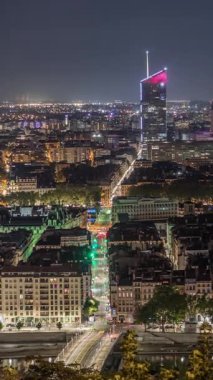 Geceleri Fourviere Hill 'den gökdelenlerle Lyon' un panoramik hava manzarası. Ufuk çizgisinde Rhone Nehri ve ikonik kent simgeleri yer alıyor. Evler çatılar ve caddelerde trafik