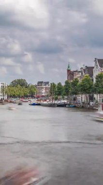 Ulusal Opera Müziği ve Tiyatro Salonu 'nun dış cephesinin aşırı hızlanması. Amsterdam 'daki nehirde, bulutlu bir gökyüzünün altında yüzen yüzen evler. Hollanda 'daki popüler turizm beldesi