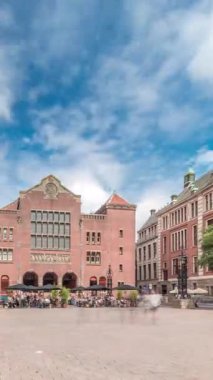Beursplein 'in tarihi Beurs van Berlage binası, eski bir emtia borsası, şimdi de konserler ve sergiler için bir mekan. Meydanda yürüyen insanlar. Amsterdam, Hollanda