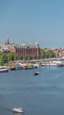 Sudaki pagoda biçiminde bir Çin restoranının hava manzarası, tarihi şehir merkezi binalarının ve nehir kıyısındaki yüzen teknelerin zeminine karşı kurulur. Amsterdam, Hollanda