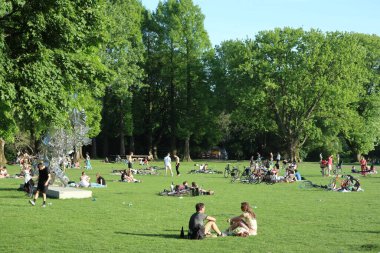 Hollanda, Amsterdam 'daki Beatrixpark' ta bir çimenlikte eğlenen insanlar.