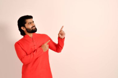 Kurta giyen ve iki eliyle işaret eden mutlu Hintli adam.