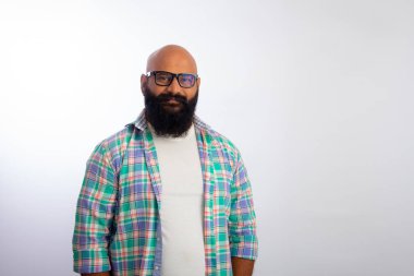 Sıradan kıyafetler ve gözlük takan Hintli kel adam kameraya bakıyor ve gülümsüyor.