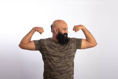 Mutlu Hintli sağlıklı orta yaşlı adam kollarını ve pazılarını gösteriyor.