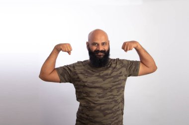 Mutlu Hintli sağlıklı orta yaşlı adam kollarını ve pazılarını gösteriyor.