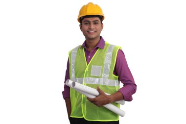 Sarı kask takan Hintli erkek mimar ve güvenlik ceketi elinde beyaz arka planın planları var. 