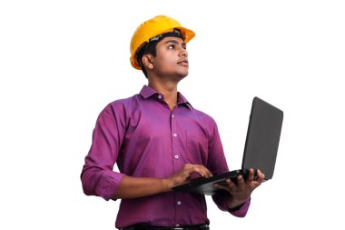 Stüdyoda dizüstü bilgisayarla poz veren sarı şapkalı yakışıklı Hintli adam.. 