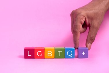 Pembe arka planda el ele tutuşan kadın.