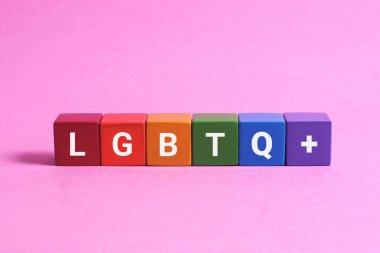 Ahşap bloklarda pembe arka planda gökkuşağı lgbt bayrağı. lgbt kavramı.