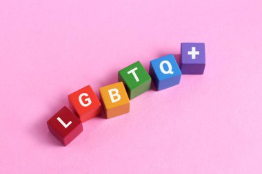 Pembe arka planda lgbtq sözcüğüyle tahta küpler
