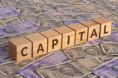 Tahta küplerin sermaye sözcüğü Hindistan rupi banknotlarının arka planında  
