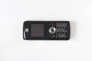 Old phone on a light background. Dusty shabby phone.