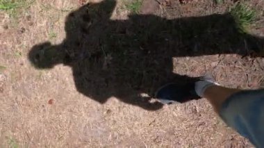 Orman yolu boyunca bir gölgenin hareketi. Bir adam yerde yürüyor..