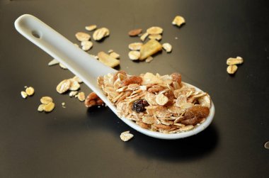 Fındıklı granola ve koyu arkaplanda kuru üzüm.. 