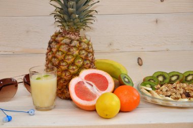 Müsli, meyve ve tahta arka planda bir bardak meyve suyu ile sağlıklı bir kahvaltı.