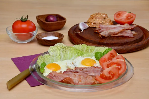 木製のテーブルの上でベーコンと卵と野菜と朝食 — ストック写真
