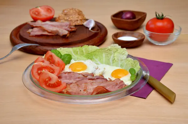 木製のテーブルの上でベーコンと卵と野菜と朝食 — ストック写真