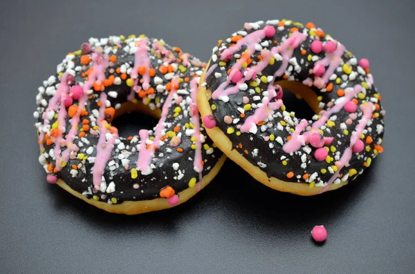 Twee Donuts Met Helder Glazuur Een Zwarte Achtergrond Close — Stockfoto