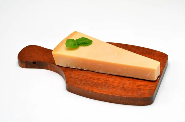 stock image a piece of hard cheese on a wooden board on a white background