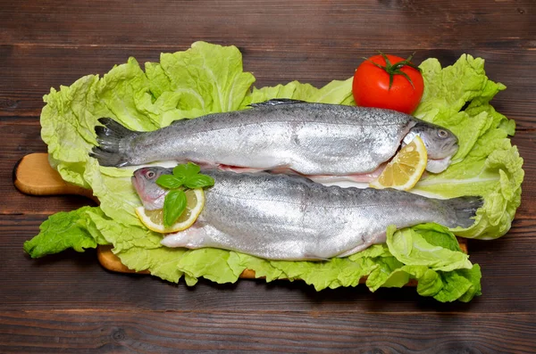 stock image prepared trout with vegetables on a wooden background