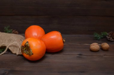 Tahta bir arka planda olgun hurma ve fındık, kopyalama alanı