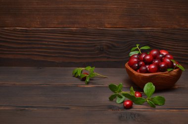 Kırsal ahşap arka planda bir kase kızılcık, kopyalama alanı