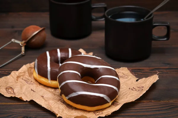 两个甜甜圈在巧克力冰和咖啡的背景下 — 图库照片