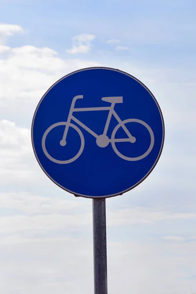 round blue bicycle sign on a pole close up
