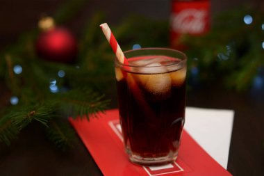 Noel ağacının arka planında ferahlatıcı bir içecek olan bir bardak.