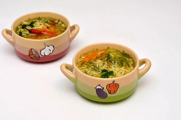 two bowls with soup on a white background