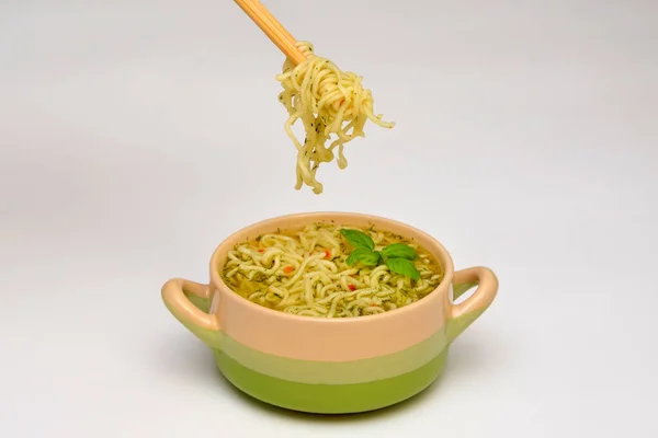 soup with chinese noodles and noodles with chopsticks