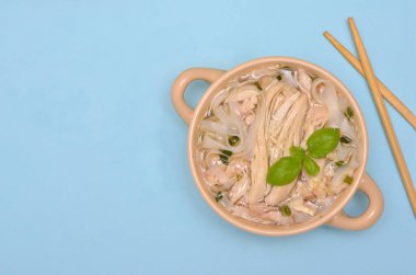 Çin erişteli çorba ve mavi arka planda tavuk, kopyalama alanı.