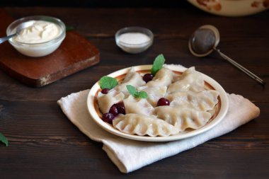 rustic still life with cherry dumplings on the table, low key