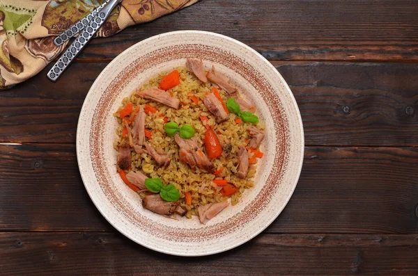 asian dish, uzbek pilaf with meat on a wooden table, flat lay