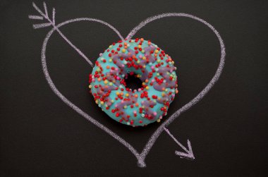 bright donut and heart drawn in chalk on a blackboard, romantic image clipart