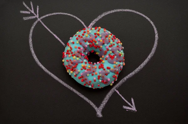 bright donut and heart drawn in chalk on a blackboard, romantic image